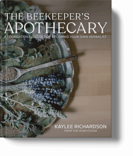 Book cover of 'The Beekeeper's Apothecary' with herbs and a spoon on a wooden surface.